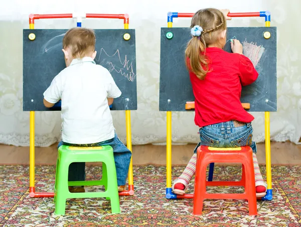Girl and boy drawing on the blackboard
