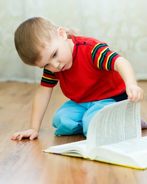 A little boy reads a book