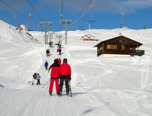Skiers going uphill on a T-bar lift