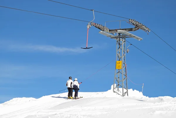Two skiers on a t-bar ski lift