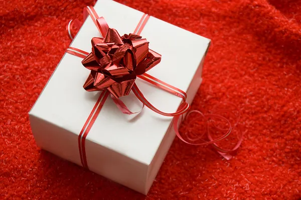 White gift box with red satin ribbon