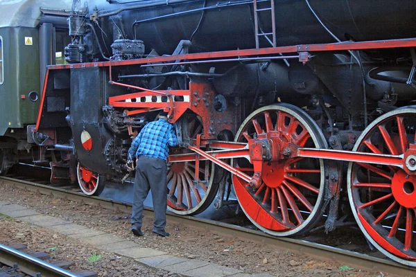 Man repairs an old steam locomotive