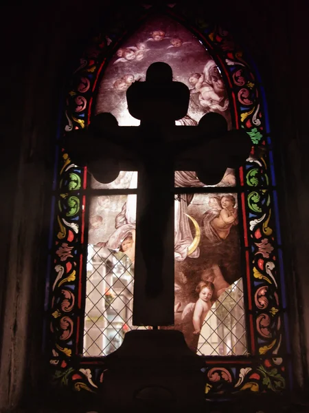 Cross in front of a stained glass
