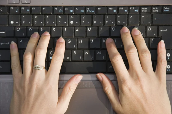 Closeup of female fingers typing on the