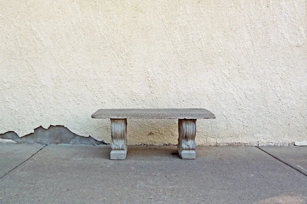Solitary concrete bench and stucco wall