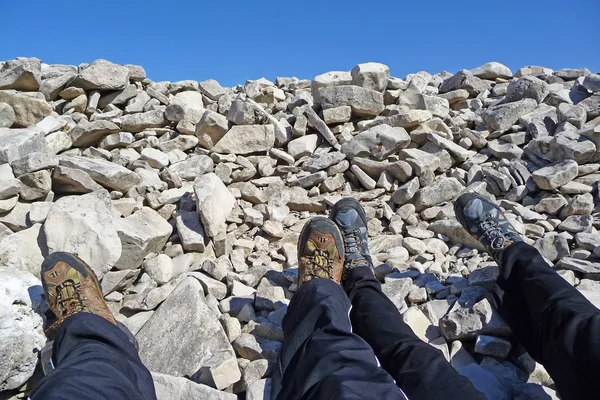 Two hikers tired feet in rocky pit