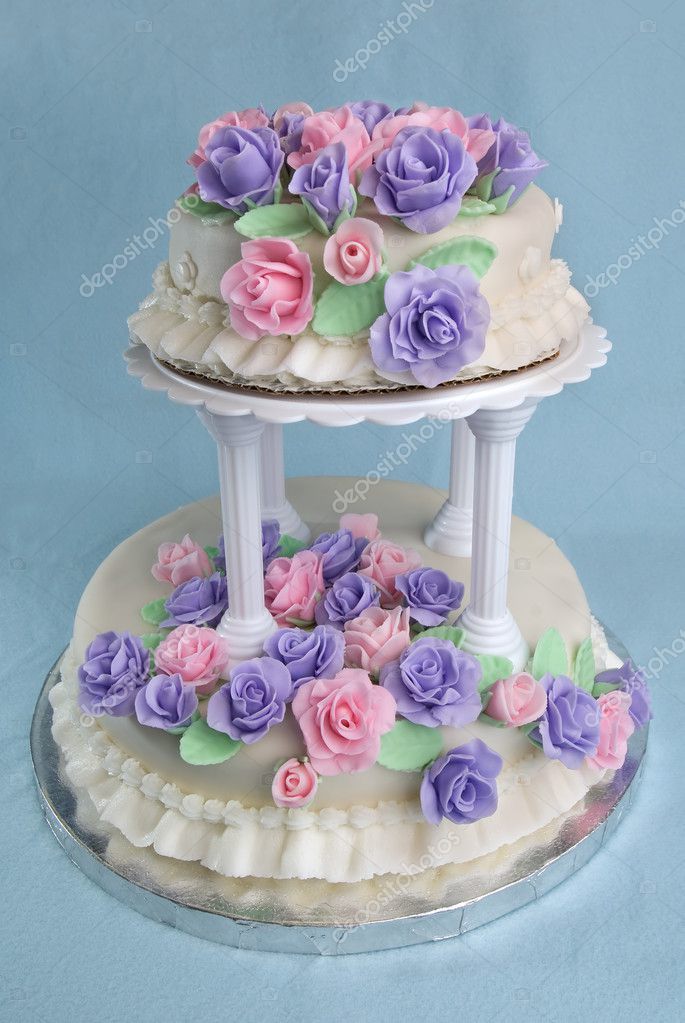 A fondantcovered twotier wedding cake covered in icing flowers
