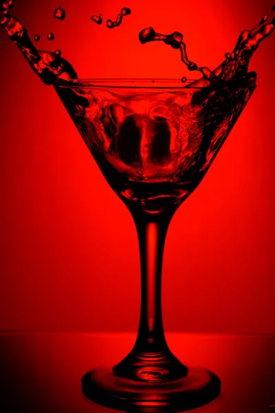 Red glass of martini with splash