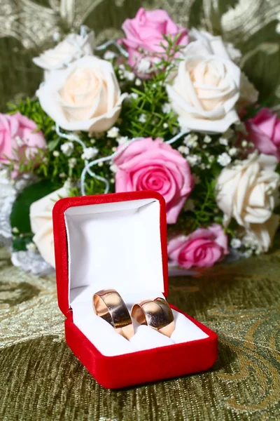 Two wedding rings in box and flowers