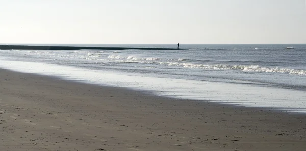 Lonely man on a deserted winter beach