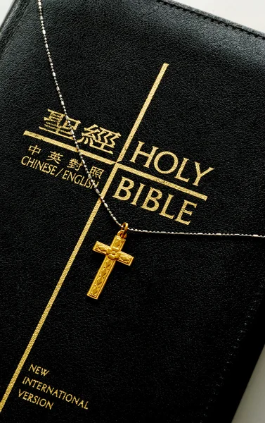A golden cross on the top of the bible