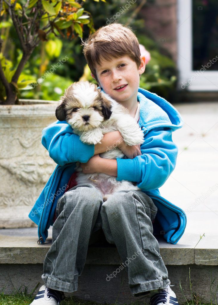 Young boy holding a lhasa apso puppy - Stock Image Young boy holding a lhasa apso puppy - Stock Image