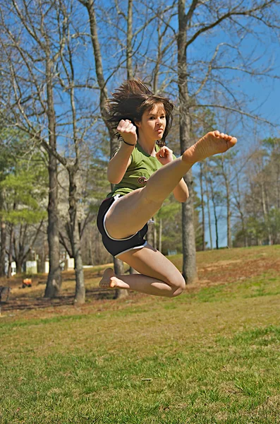 Teen girl performing martial arts kick