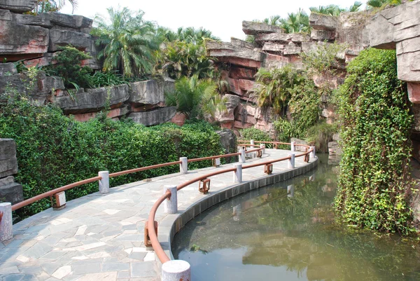 The wood board bridge in a water pond garden in a tropical resort China.