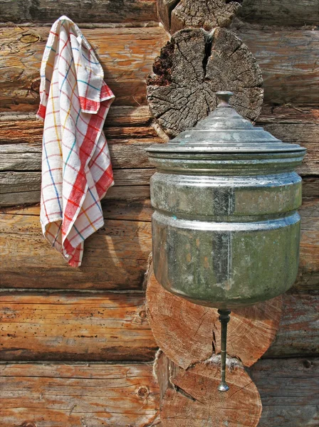 Towels and wash basin on wooden wall