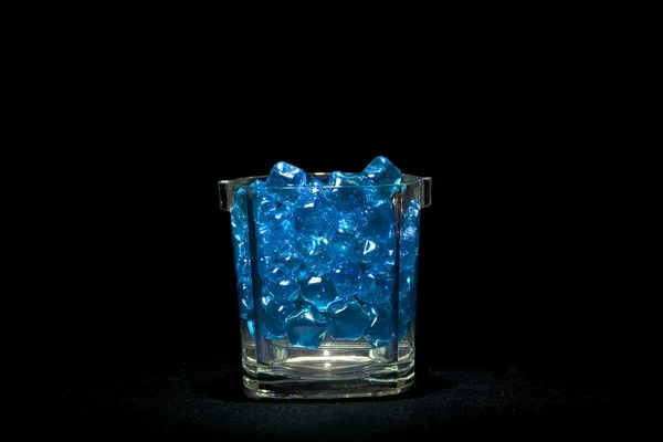 Backlit blue glass marbles on black