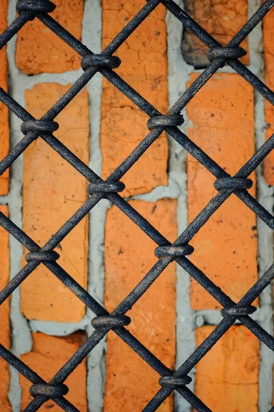 Pattern of iron grid and red brickwall