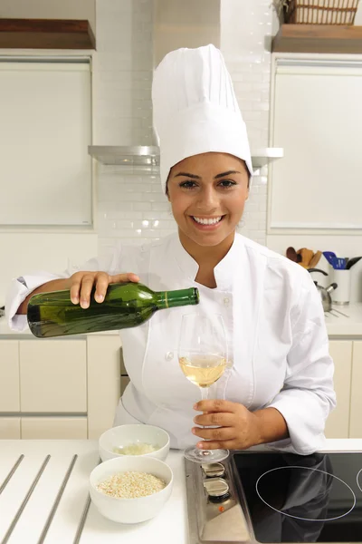 Happy chef cooking using white wine