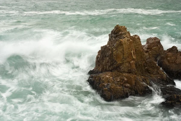 Waves crashing into big rocks