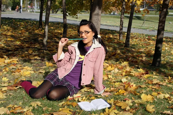 Funny college girl studying in autumn pa