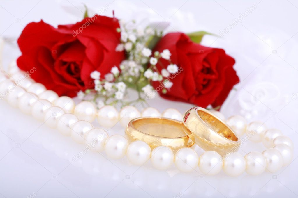 Still life with golden wedding rings and red roses