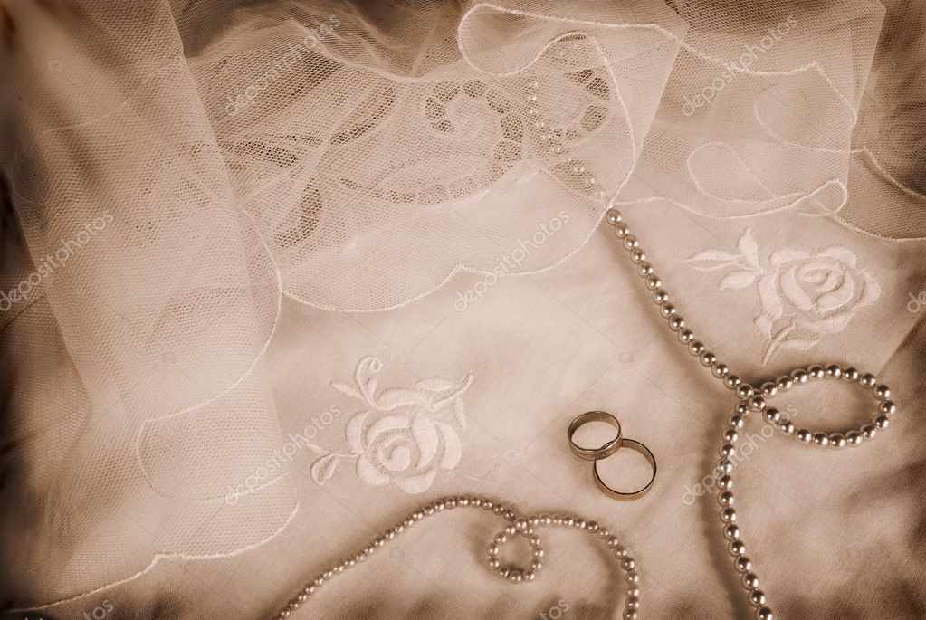 Romantic grunge wedding arrangement with rings pearls on vintage veils