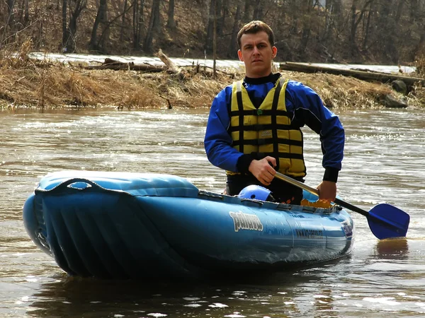 Young man on inflatable canoe
