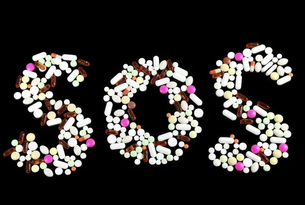 Pills forming the word SOS