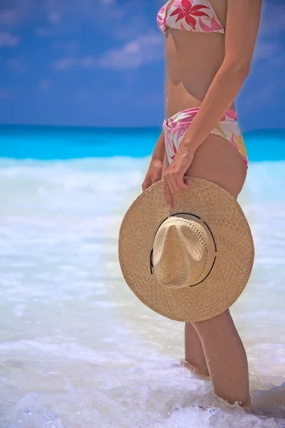 Woman with hat standing on the beach