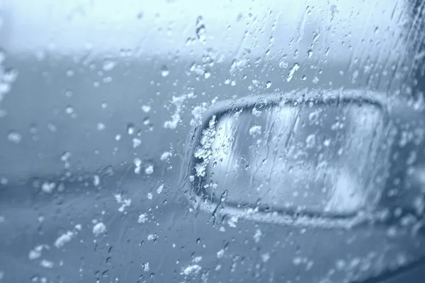 Water drops and snowflakes on car window