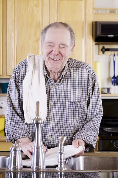 Elderly man washing dishes