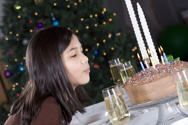 Little girl blowing birthday cake