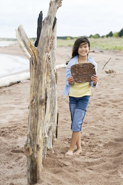 Little girl on beach holding sign