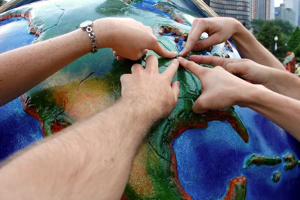 S fingers pointing at globe