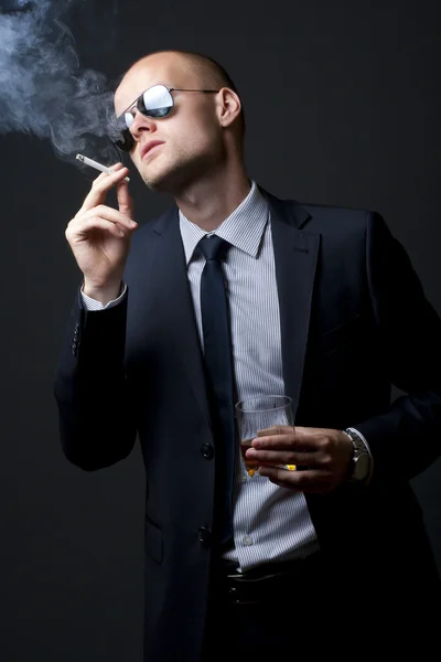 Young businessman drinking and smoking