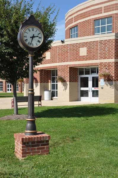 Clock by a modern brick building