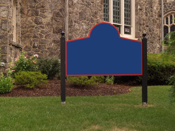 Blank sign by a stone building