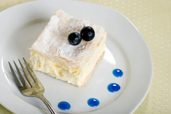 Custard cake square on a plate with fork