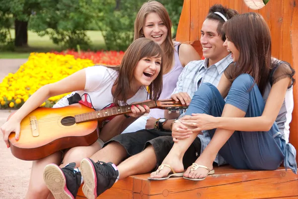 Four young friends play the guitar