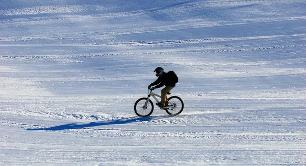 Mountain biker downhill on ski resort slope