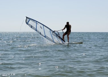 Windsurfer heaving a sail clipart