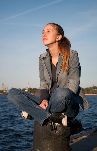 Jonge meisje zit in de buurt van de rivier — Stockfoto
