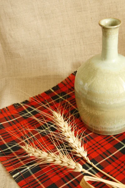 Ceramic Jar And Wheat on red — Stock Photo, Image