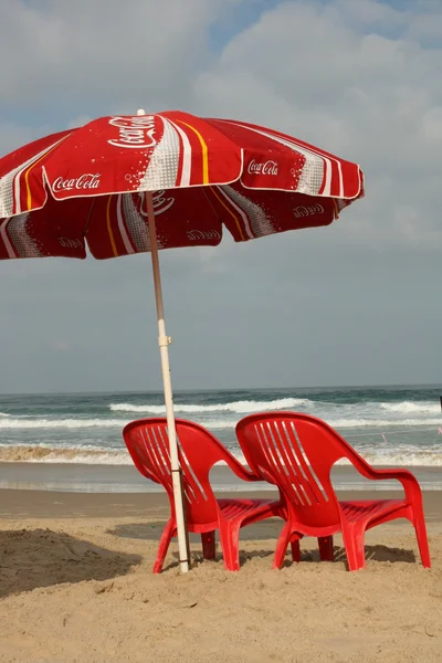 Red chairs and umbrella on the beach — Stock Photo, Image