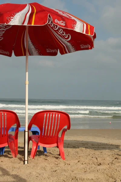 Red chairs and umbrella on the beach — Stock Photo, Image