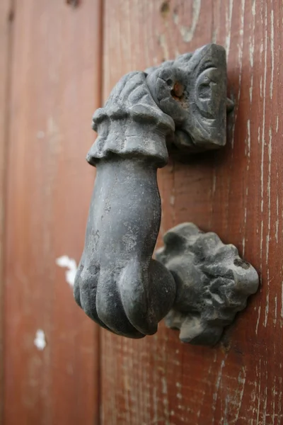 Старая металлическая дверная ручка на деревянной двери — стоковое фото