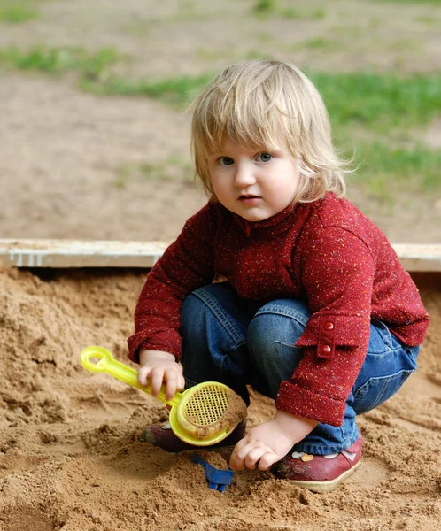 Criança brinca com areia — Fotografia de Stock