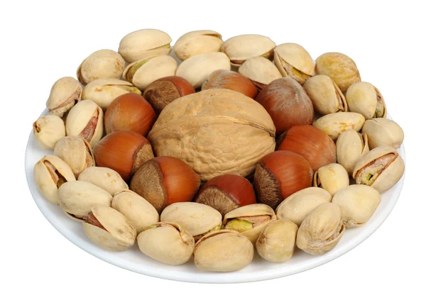 Set of nuts on a white plate, isolation — Stock Photo, Image