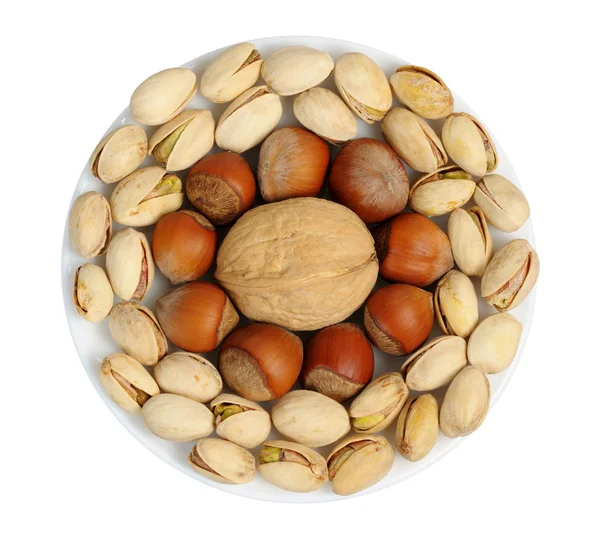 Set of nuts on a white plate, isolation — Stock Photo, Image