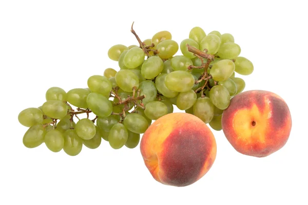 Green grapes bunch and two orange peach. — Stock Photo, Image